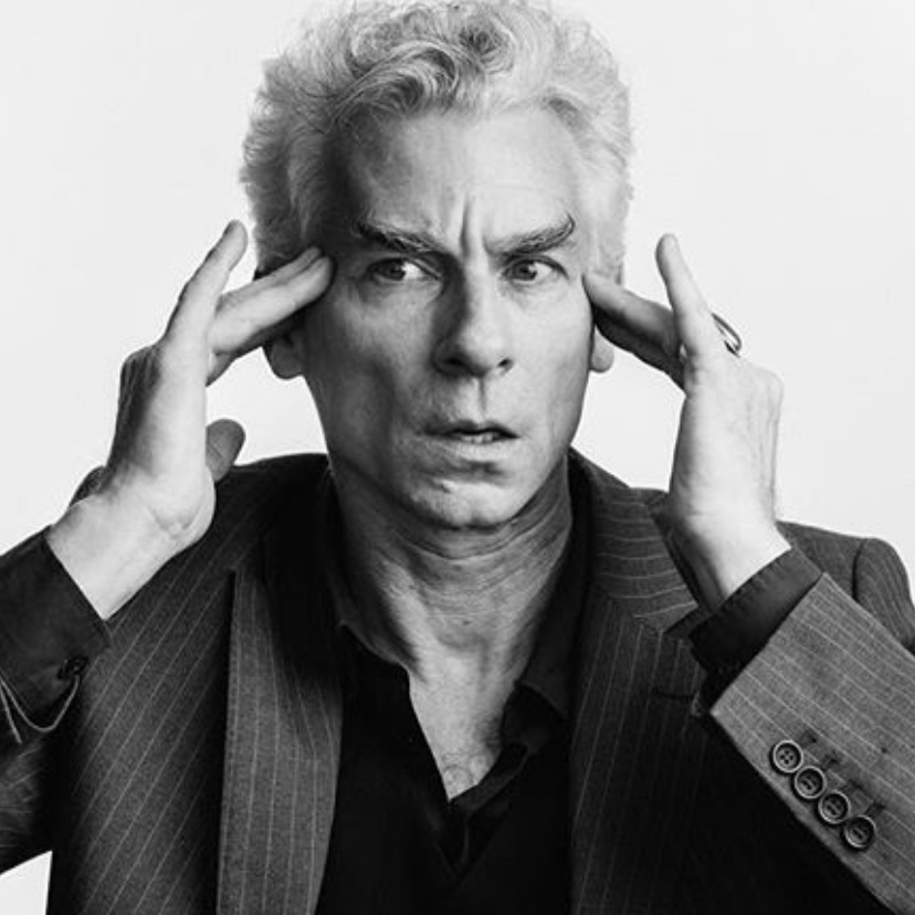 man with his fingers holding his temples - as if he is receiving a message